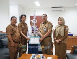 Pj. Sekda Kabupaten Pesisir Barat Menyerahkan Piala kepada Keza Filenita yang Meraih Juara Terbaik 3 dalam Lomba Pidato Bahasa Lampung Tingkat Provinsi